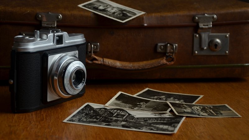 Eine Kamera, ein Koffer und alte Fotoaufnahmen